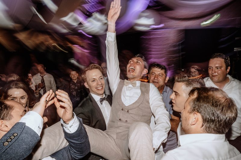 Bräutigam wird von Gästen auf der russischen Hochzeitsparty hochgehoben