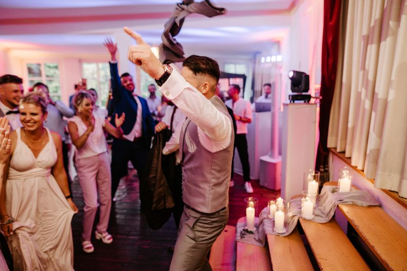 Bräutigam wirft sein Jacket auf der Hochzeitsparty – bequeme Kleidung zum Feiern