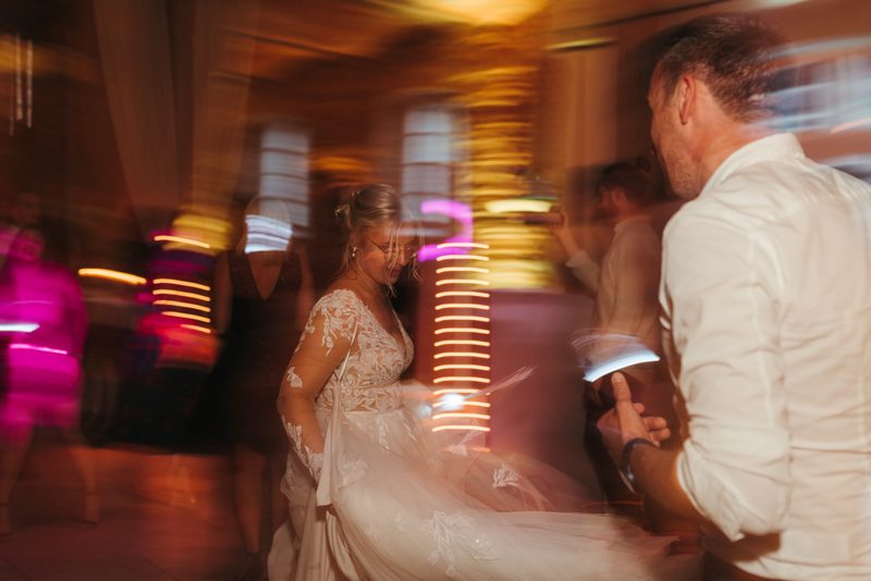 Braut tanzt mit bunten Lichteffekten auf der Hochzeitsparty