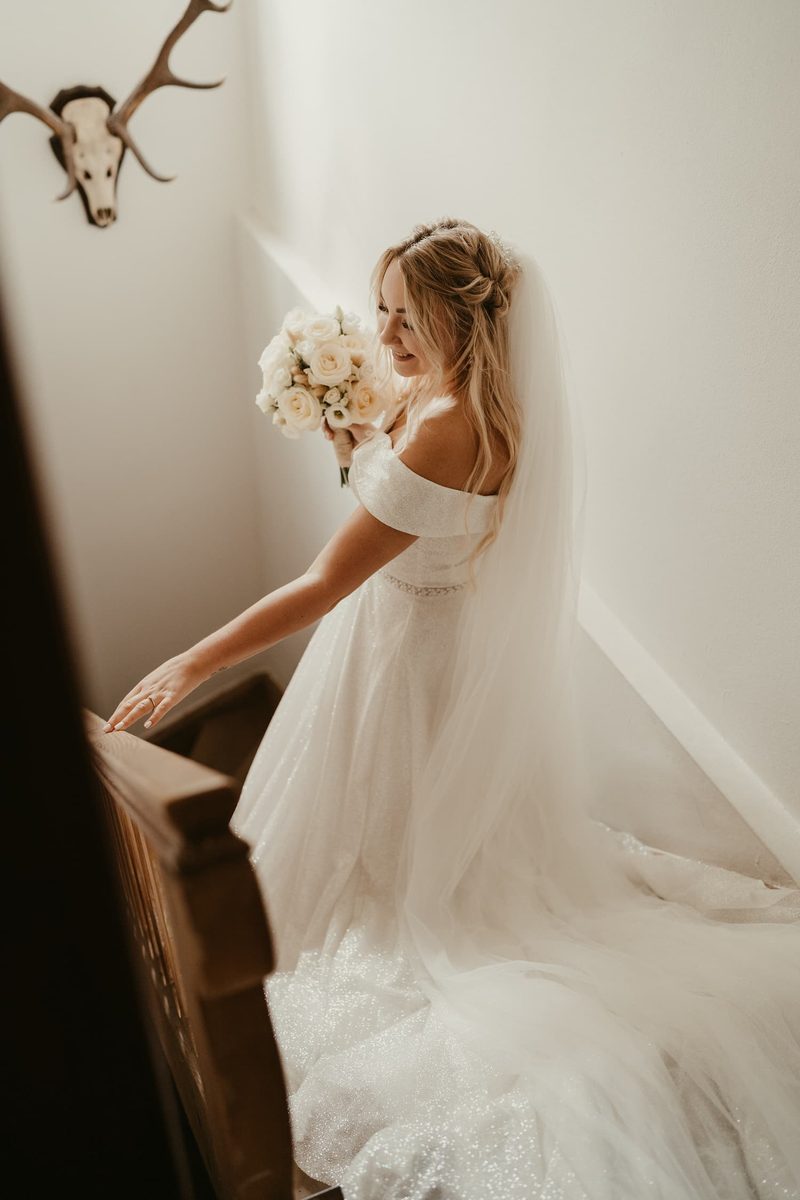 Braut auf der Treppe in Hochzeitskleid