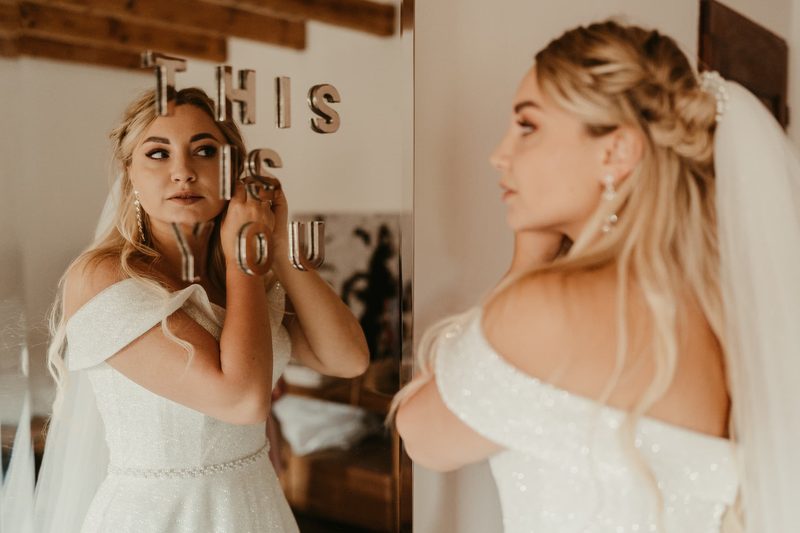 Braut in weißem Kleid beim Getting Ready